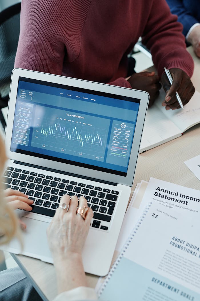 who-we-are Collaborative business meeting with data analysis on laptop and financial papers.